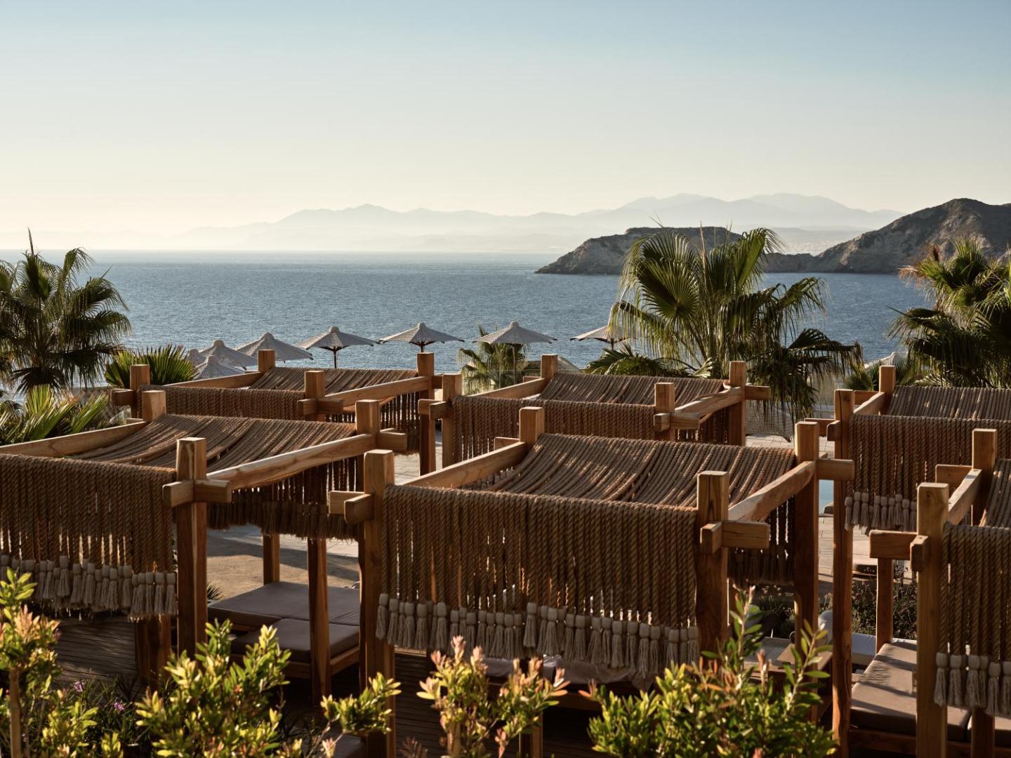 Seaside A Lifestyle Resort atpūtas zona ar dizaina saulessargiem un skatu uz jūru Agia Pelagia līcī Krētā