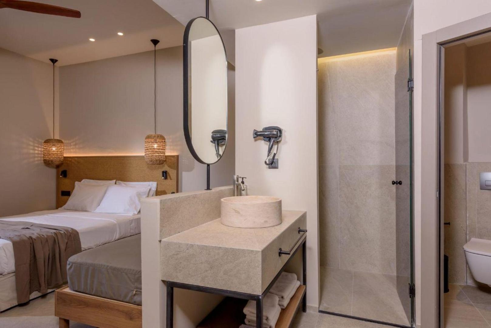 Zeus Hotels Neptuno Beach numura vannas istabas zona ar akmens izlietni un modernu dušu gaišā interjerā