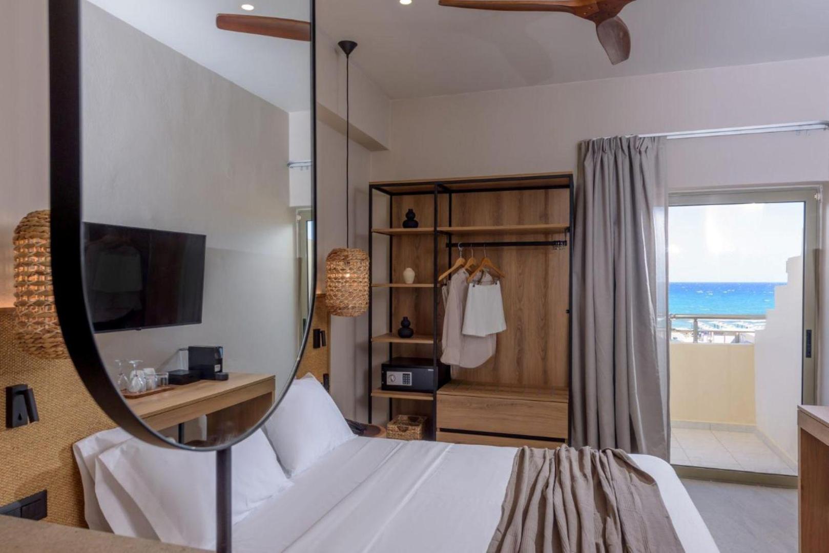 Skats no Zeus Hotels Neptuno Beach numura uz balkonu ar skatu uz Vidusjūru — gaišs interjers un koka mēbeles
