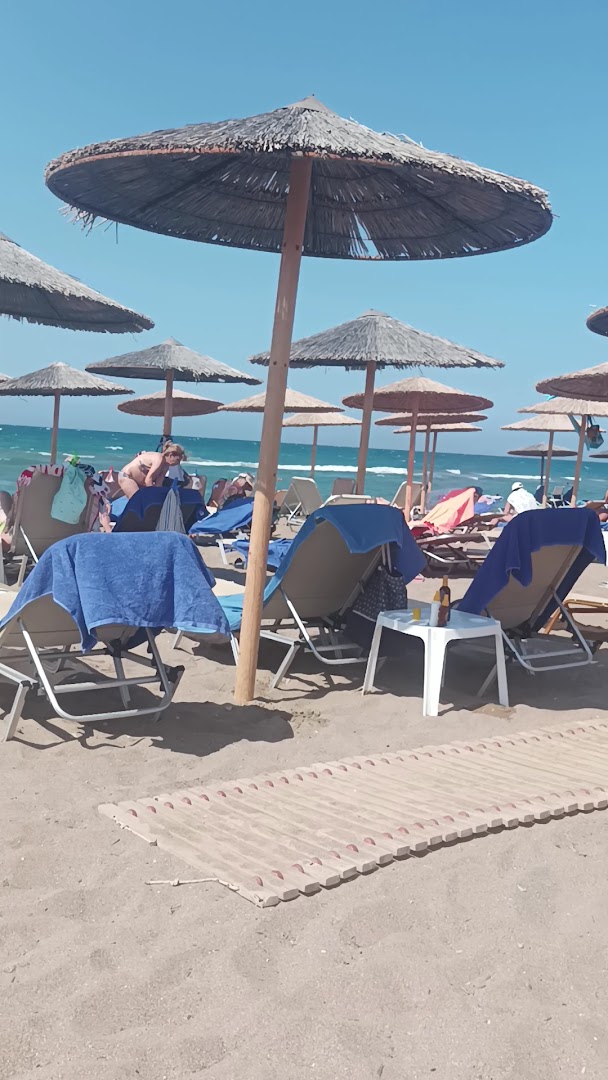 Viesnīcas Neptuno Beach privātā pludmale ar salmu saulessargiem un zviļņiem Amudaras piekrastē saulainā dienā