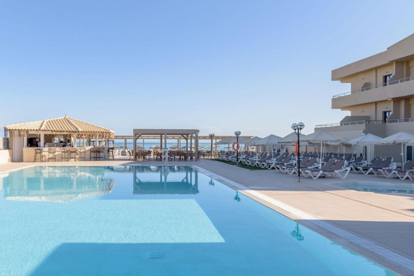 Skats uz Neptuno Beach baseinu, bāru un atpūtas krēsliem ar skatu uz jūras horizontu Amudarā