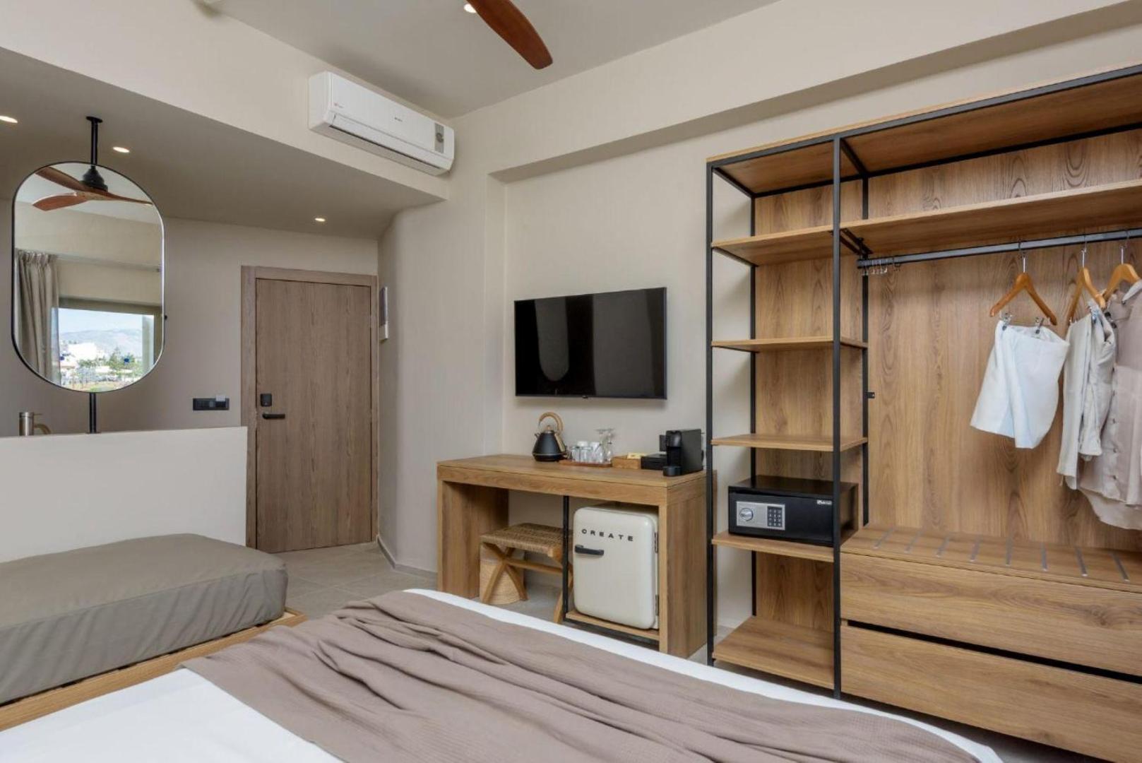 Zeus Hotels Neptuno Beach moderns numurs ar atvērtā tipa drēbju skapi, darba galdu un plakanā ekrāna televizoru Amudarā, Krētā