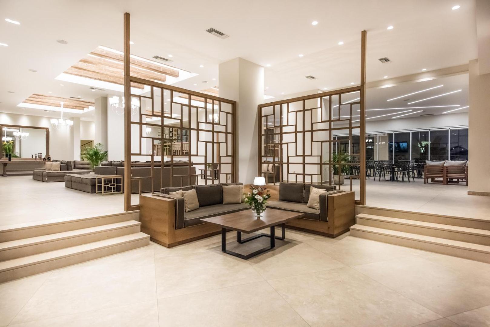 Plašs Nana Golden Beach viesnīcas lobby ar modernu dizainu, koka starpsienām un vairākām atpūtas zonām
