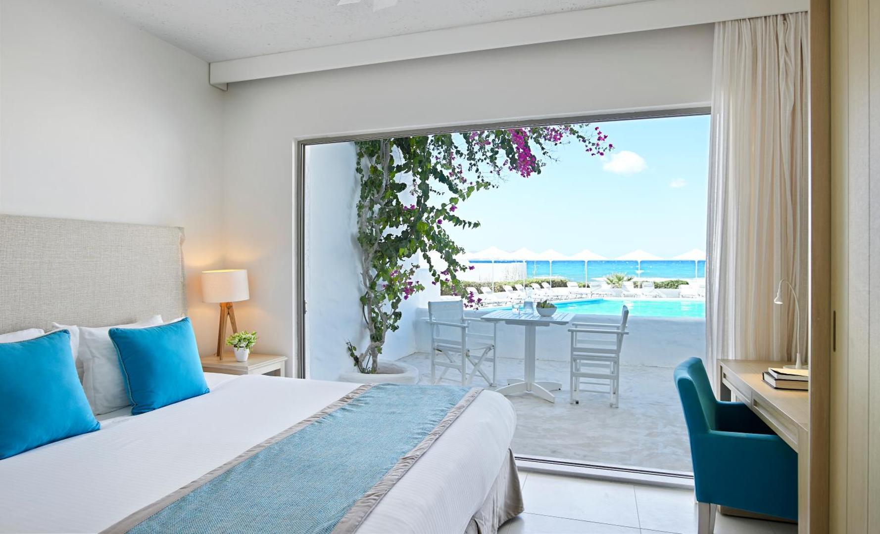 Knossos Beach Bungalows Resort numurs ar terasi, no kuras paveras skats uz viesnīcas baseinu un jūru