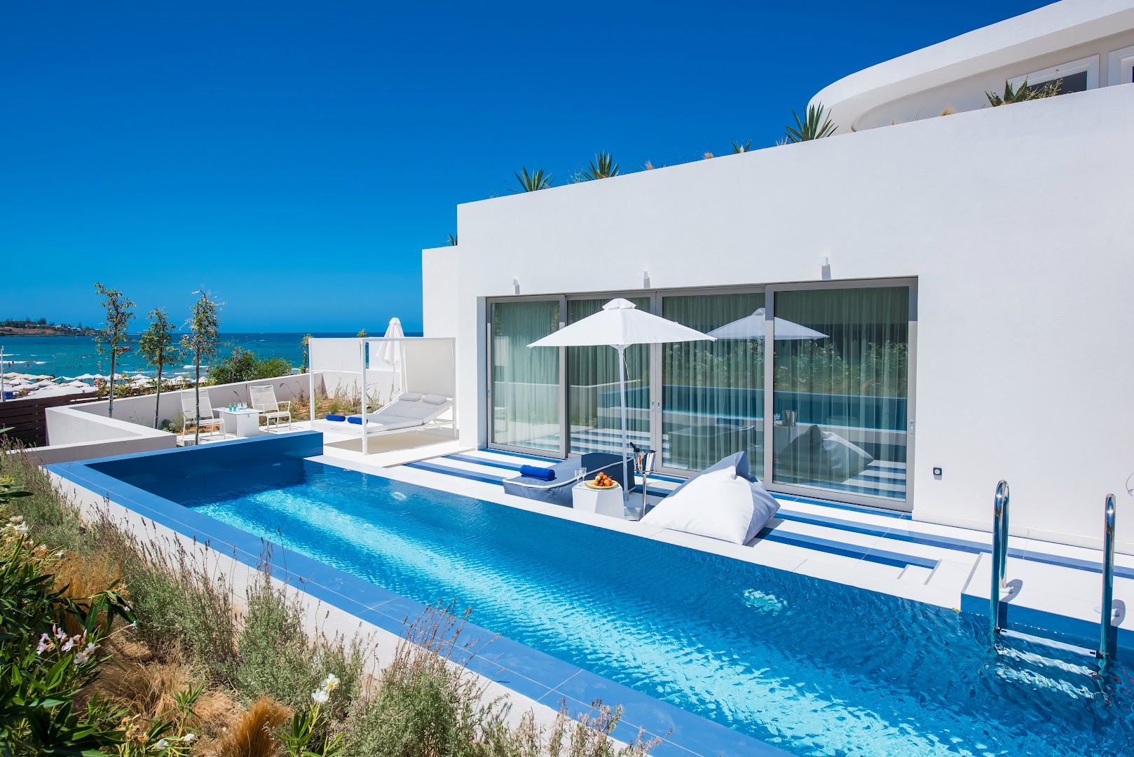 I-Resort Beach Hotel & Spa modernā arhitektūra ar privātu baseinu, sauļošanās krēsliem un skatu uz jūru skaidrā dienā