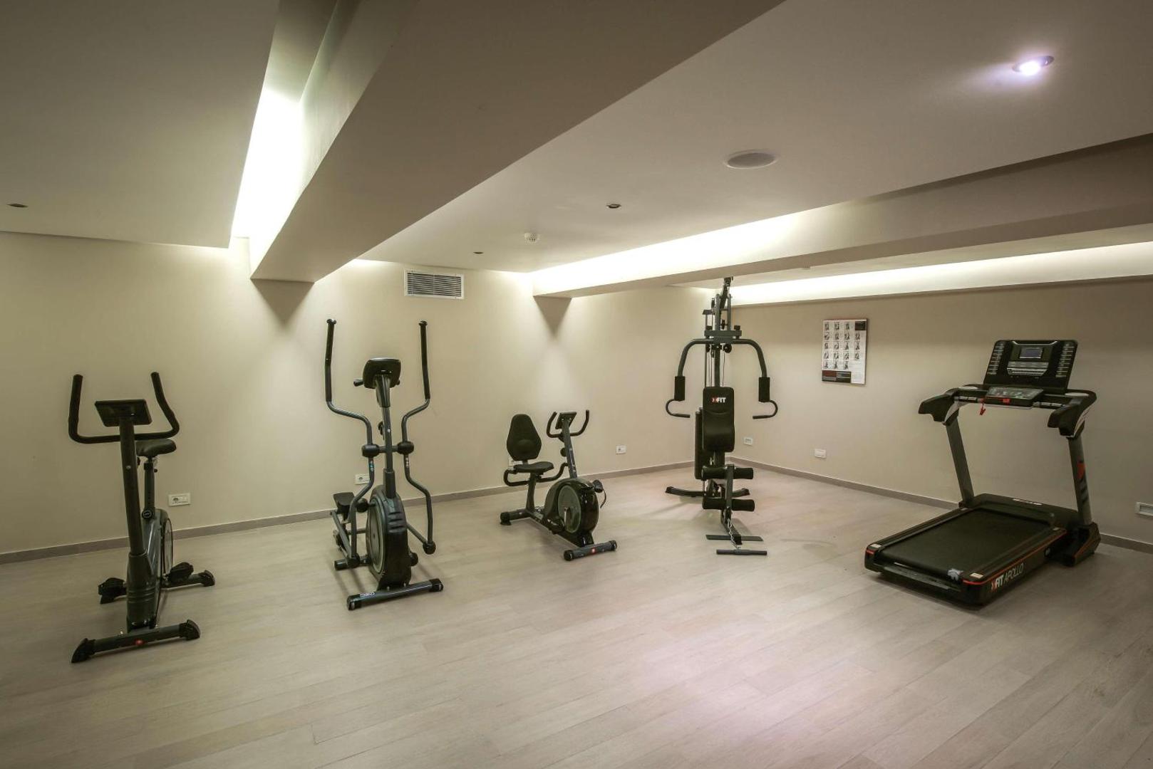 I-Resort Beach Hotel & Spa fitnesa zāle ar moderniem trenažieriem, skrejceliņu un velotrenažieriem gaišā un plašā telpā