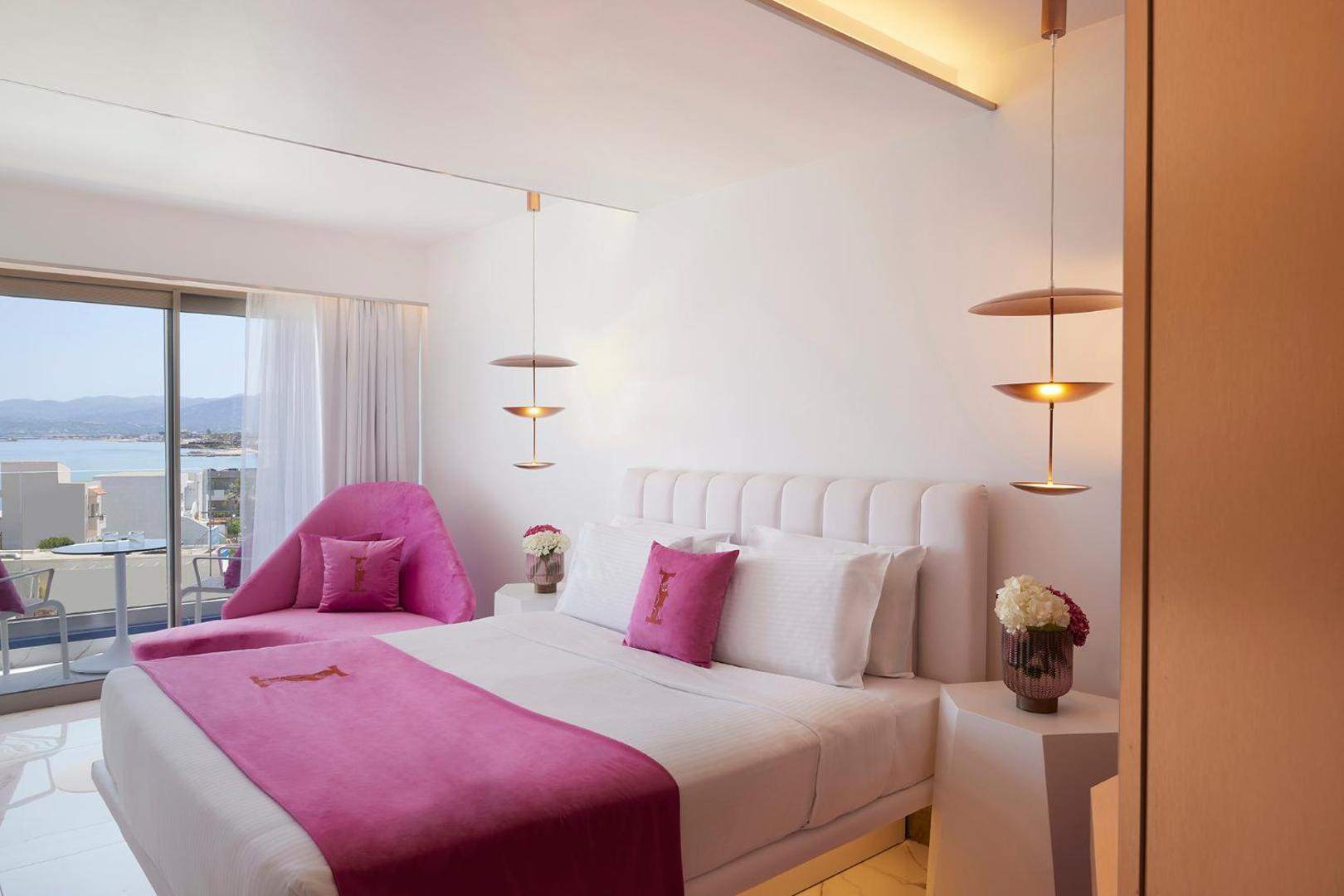 I-Resort Beach Hotel & Spa elegants numurs ar rozā akcentiem, dizaina lampām un balkonu, no kura paveras skats uz piekrasti