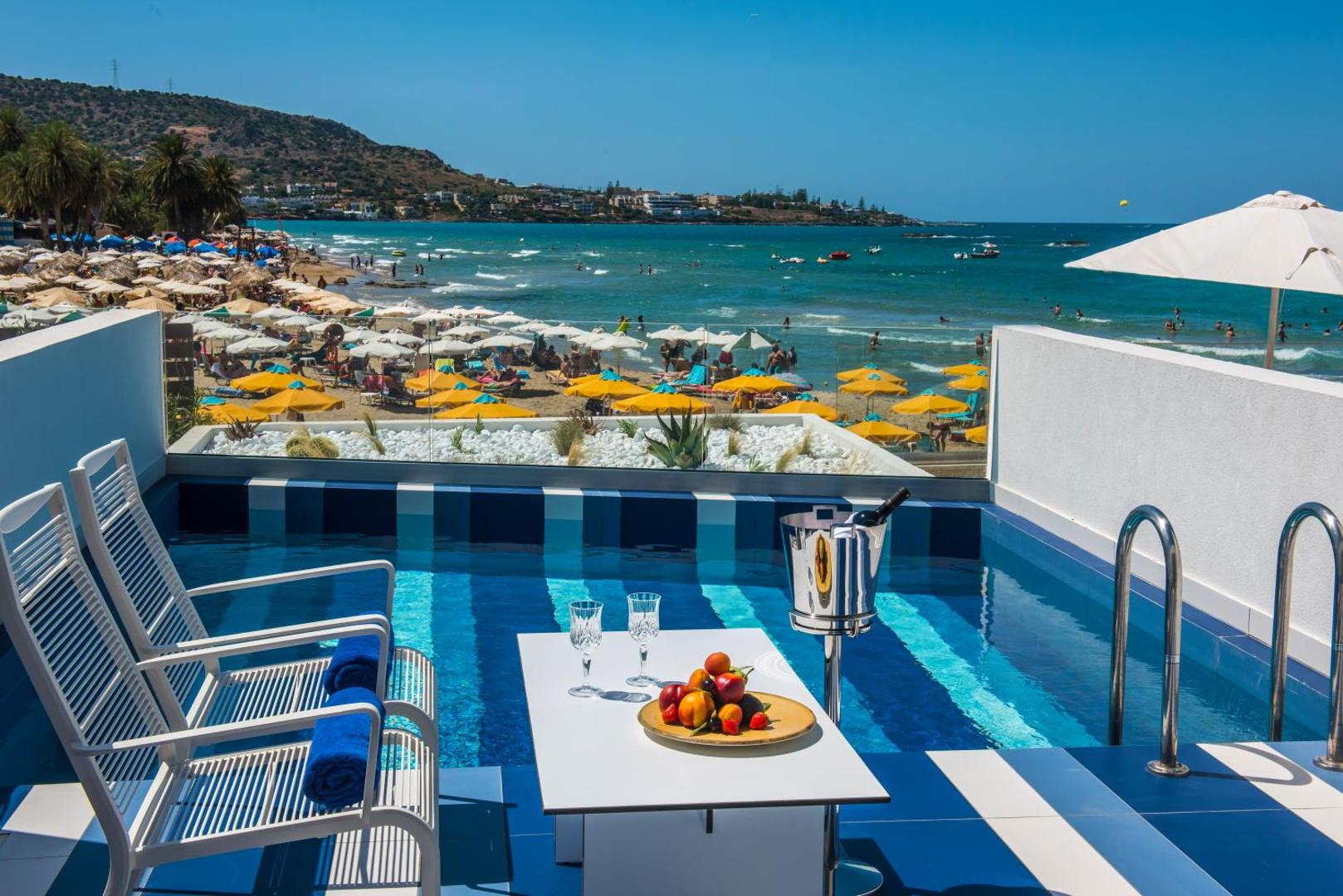 I-Resort Beach Hotel & Spa privātais baseins uz terases ar skatu uz Stalidas pludmali Krētā, saulessargiem un jūras panorāmu