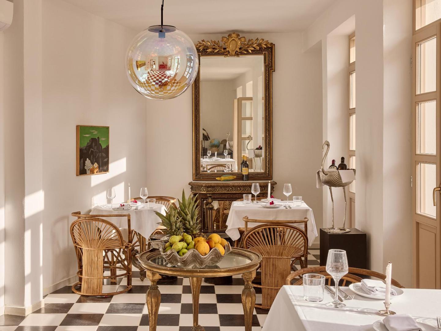 Grecotel Creta Palace Resort restorāna interjers ar šaha raksta grīdu, antīku spoguli un dizaina elementiem