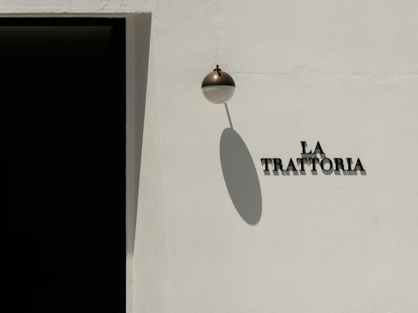 Grecotel Creta Palace itāļu restorāna La Trattoria ieeja — minimālistisks dizains un balta arhitektūra ar stilīgu apgaismojumu
