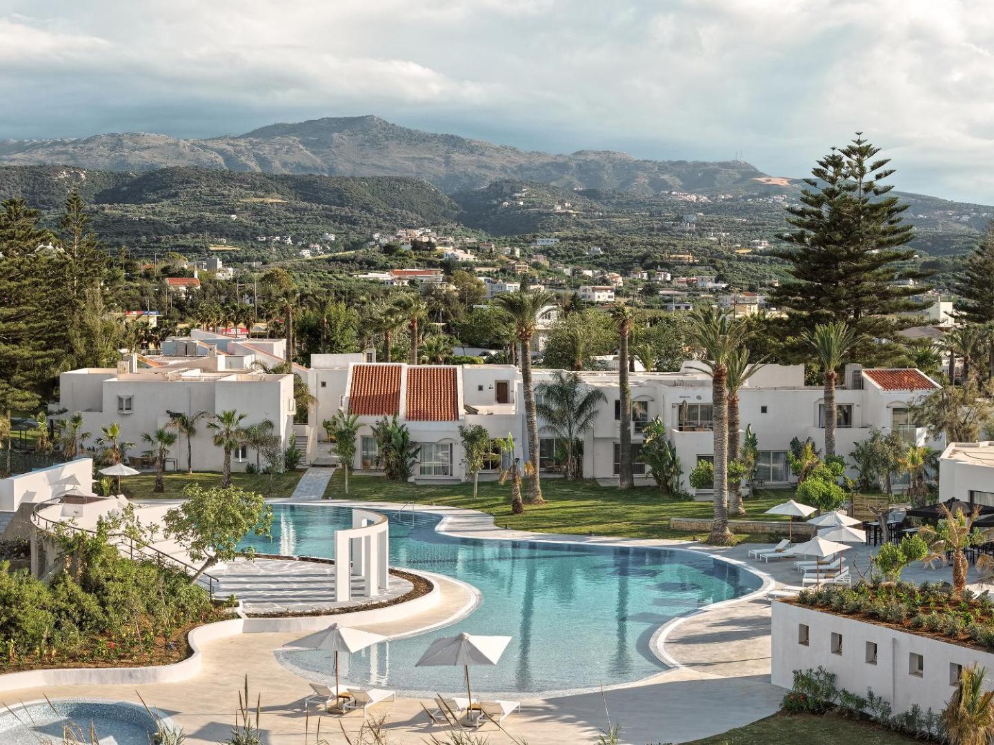 Grecotel Creta Palace Resort panorāmas skats uz baseinu, dārzu un kalniem fonā Retimno reģionā, Krētā