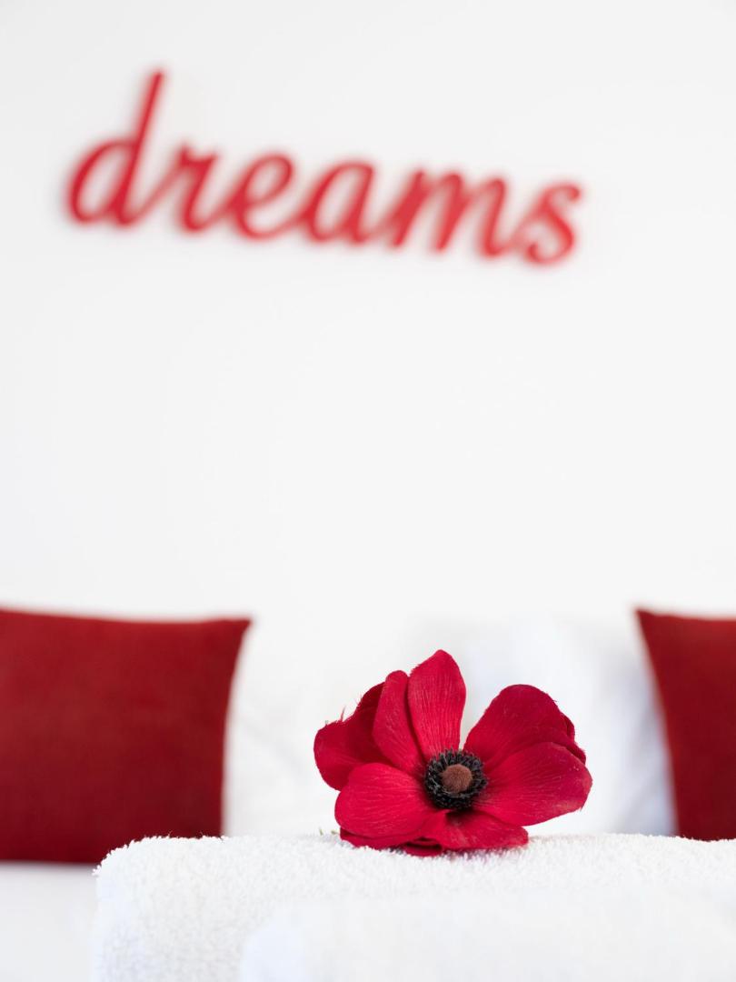Eva Mare Hotel & Suites interjera detaļa ar sarkanu ziedu uz baltiem dvieļiem un dekoratīvu uzrakstu dreams fonā