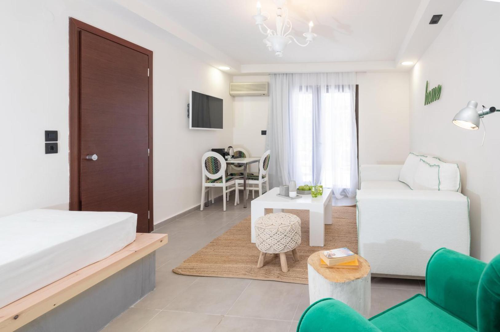 Eva Mare Hotel & Suites plašs viesnīcas numurs ar atpūtas zonu, dīvānu, kafijas galdiņu un modernu interjeru gaišos toņos