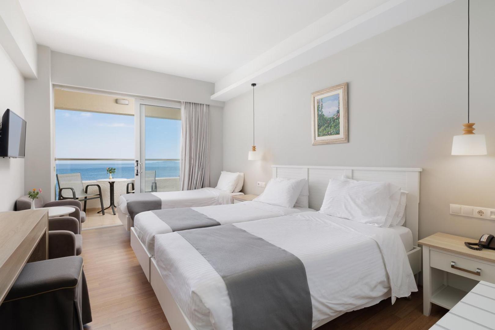 Elea Beach Hotel trīsvietīgs numurs ar trim gultām un balkonu piekrastē — piemērots ģimenēm vai draugu grupām