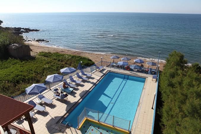 Danaos Beach Apartments skats no augšas uz baseina zonu un blakus esošo smilšu pludmali Krētas piekrastē