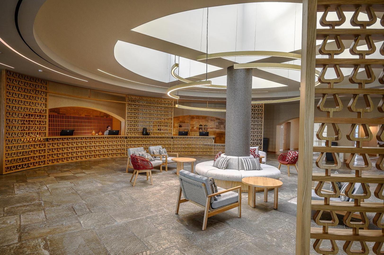 Creta Maris Resort modernā lobby zona ar akmens grīdu, dizaina mēbelēm un unikālu griestu apgaismojumu Hersonisā, Krētā