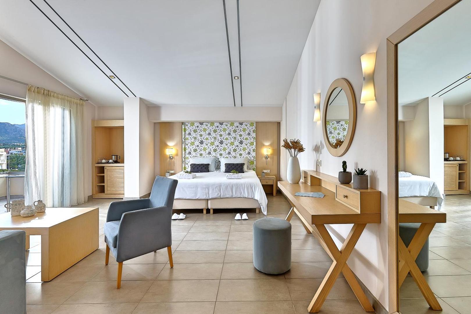 Plašs Castello Boutique Resort & Spa junior suite numurs ar atpūtas zonu, koka mēbelēm un lielu spoguli