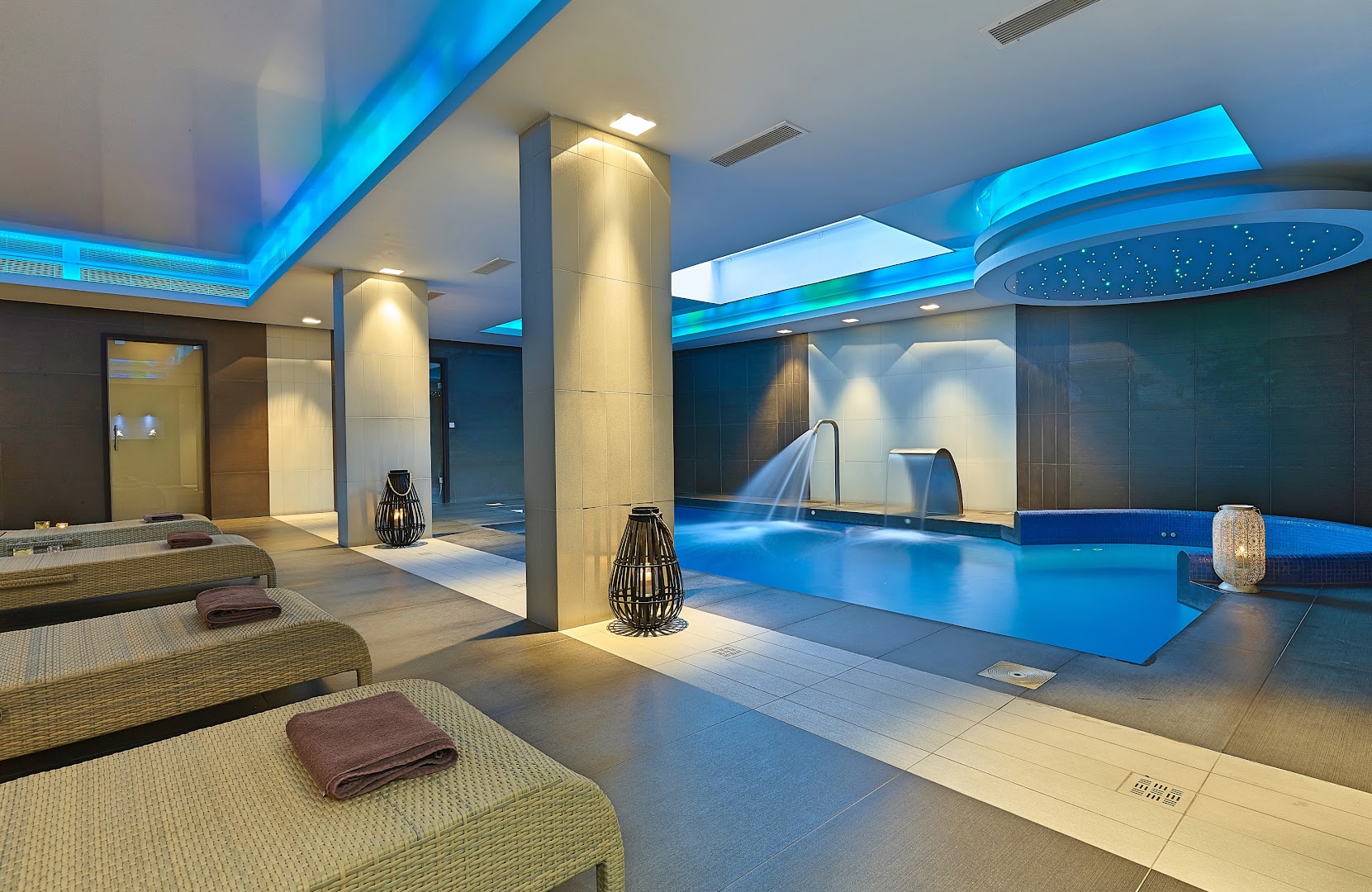 Castello Boutique Resort & Spa iekštelpu baseins ar kaskādēm, zilu apgaismojumu un ērtiem zviļņiem relaksācijai spa centrā