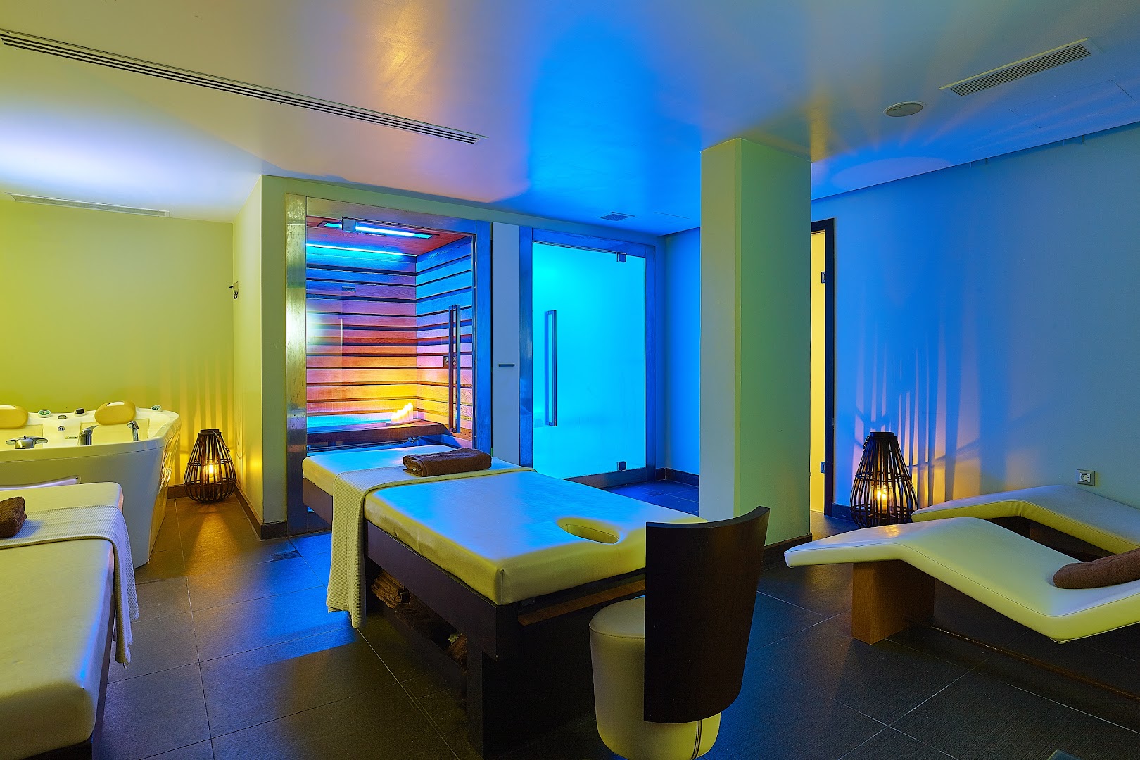 Castello Boutique Resort & Spa spa procedūru telpa ar masāžas galdiem, džakuzi un modernu apgaismojumu labsajūtas kūrortā