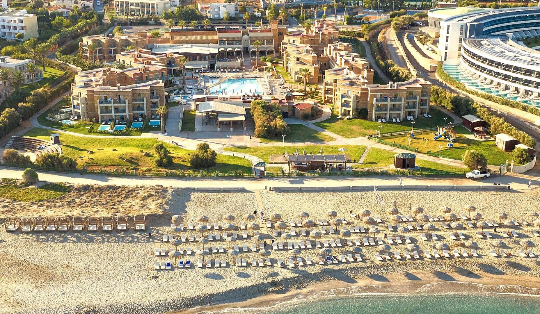 Bella Beach Hotel skats no putna lidojuma uz kūrorta teritoriju, centrālo baseinu, bērnu rotaļu laukumu un plašo smilšu pludmali Krētā