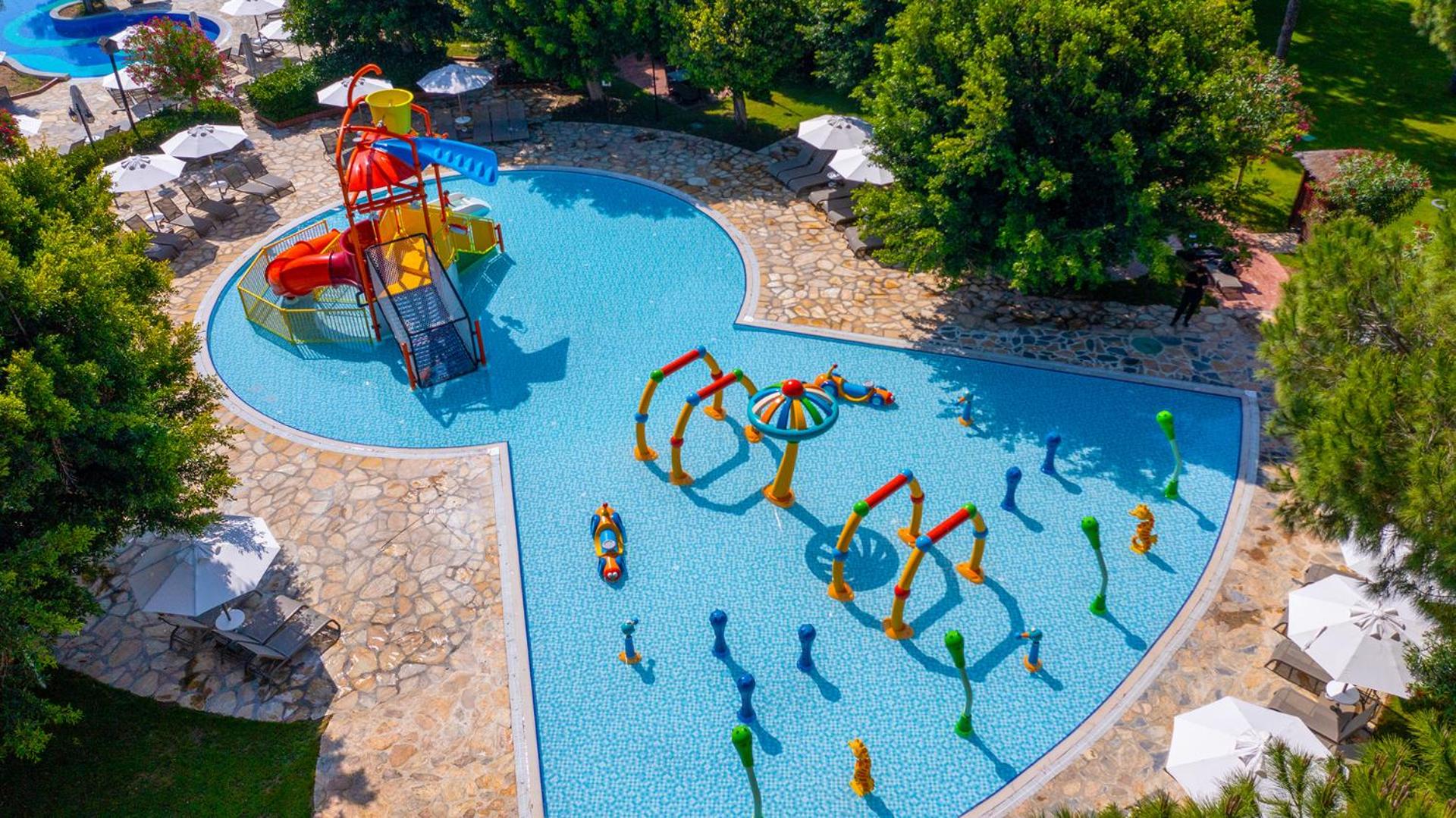 Gloria Golf Resort bērnu ūdens atrakciju parks ar seklu baseinu, maziem slidkalniņiem un strūklakām drošai atpūtai ģimenēm