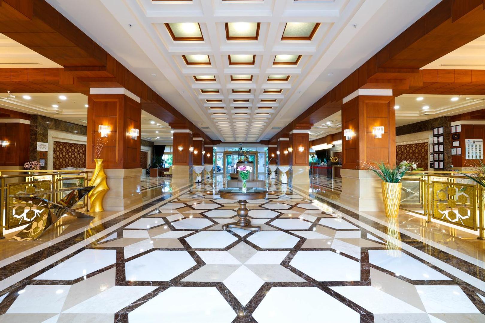 Crystal Palace Luxury Resort & Spa greznais vestibils ar marmora grīdu, koka kolonnām un dekoratīviem griestiem Sides reģionā