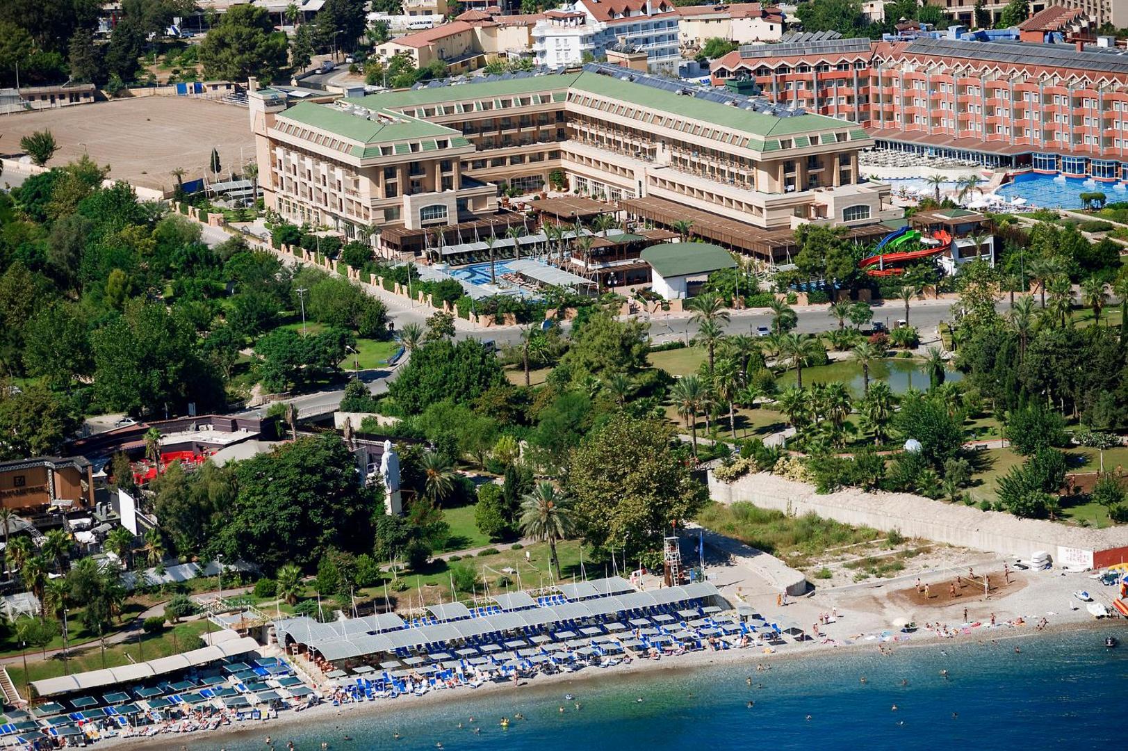 Crystal Palace Luxury Resort & Spa privātā pludmale ar saulessargiem un guļamkrēsliem, skats uz viesnīcas galveno ēku un dārzu