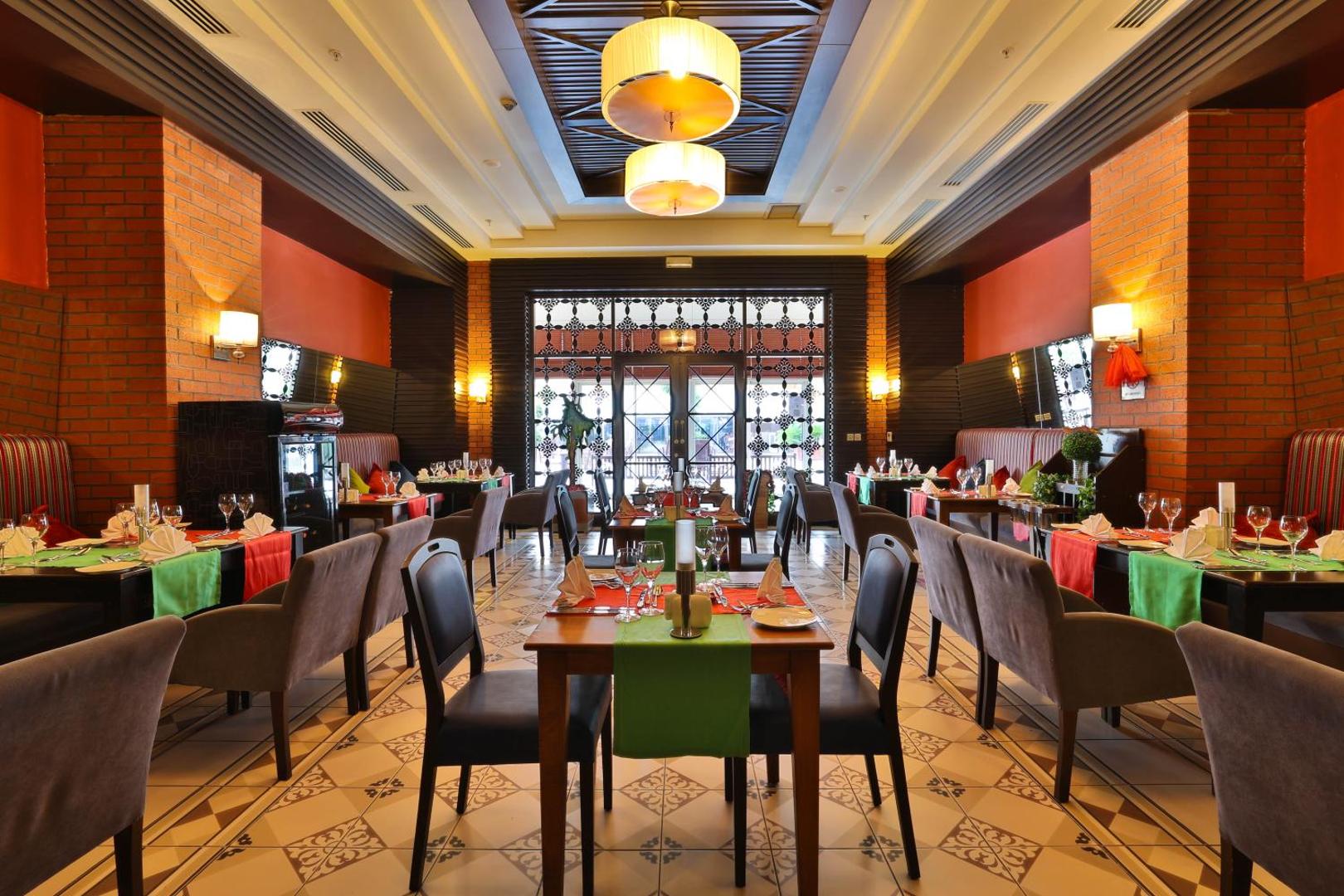 Crystal Palace Luxury Resort & Spa restorāns ar eleganti klātiem galdiem, ķieģeļu apdari un mājīgu apgaismojumu vakariņām.