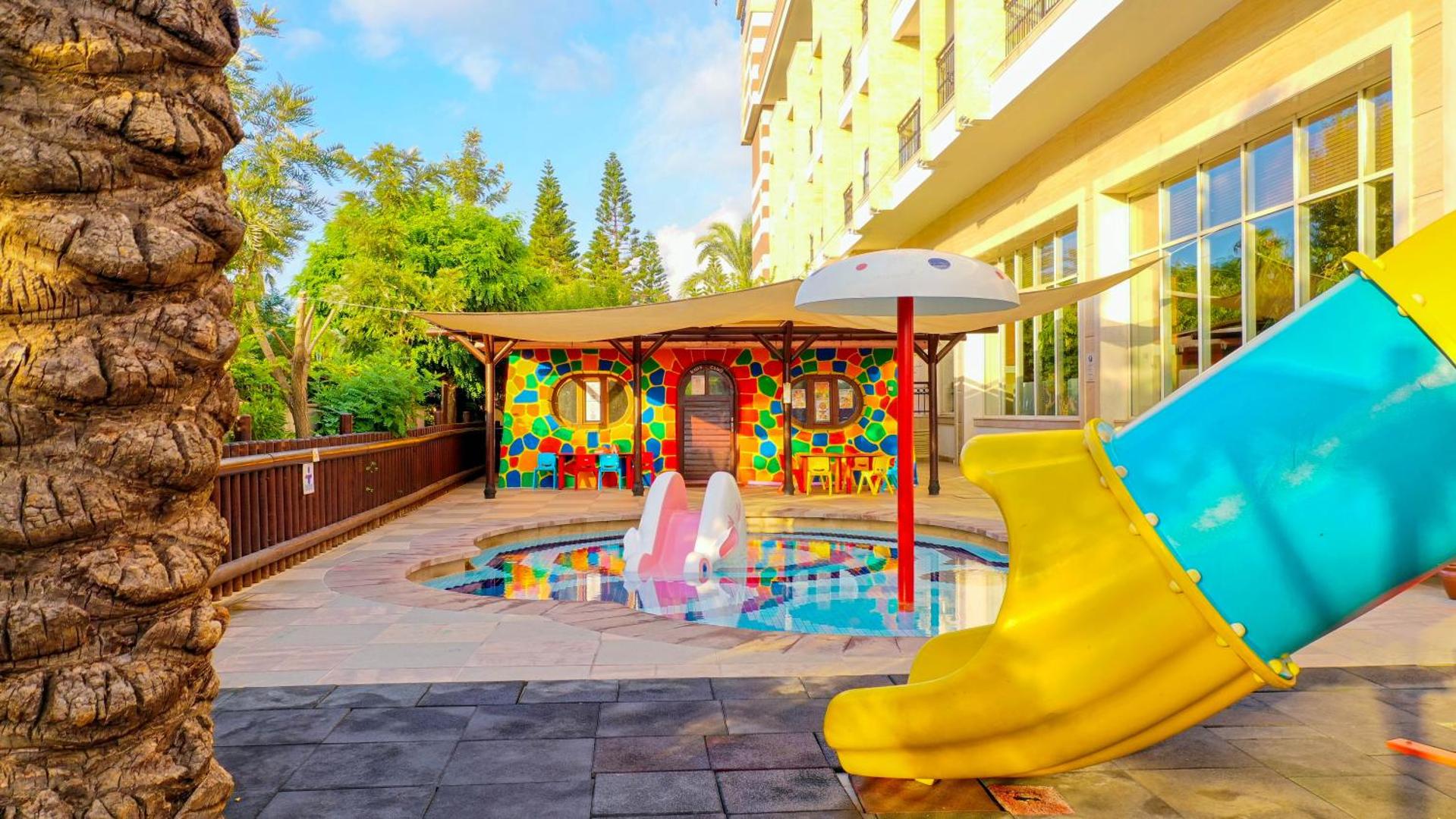 Crystal Palace Luxury Resort & Spa bērnu baseins ar slidkalniņu un krāsainu rotaļu mājiņu — droša un jautra atpūtas zona bērniem