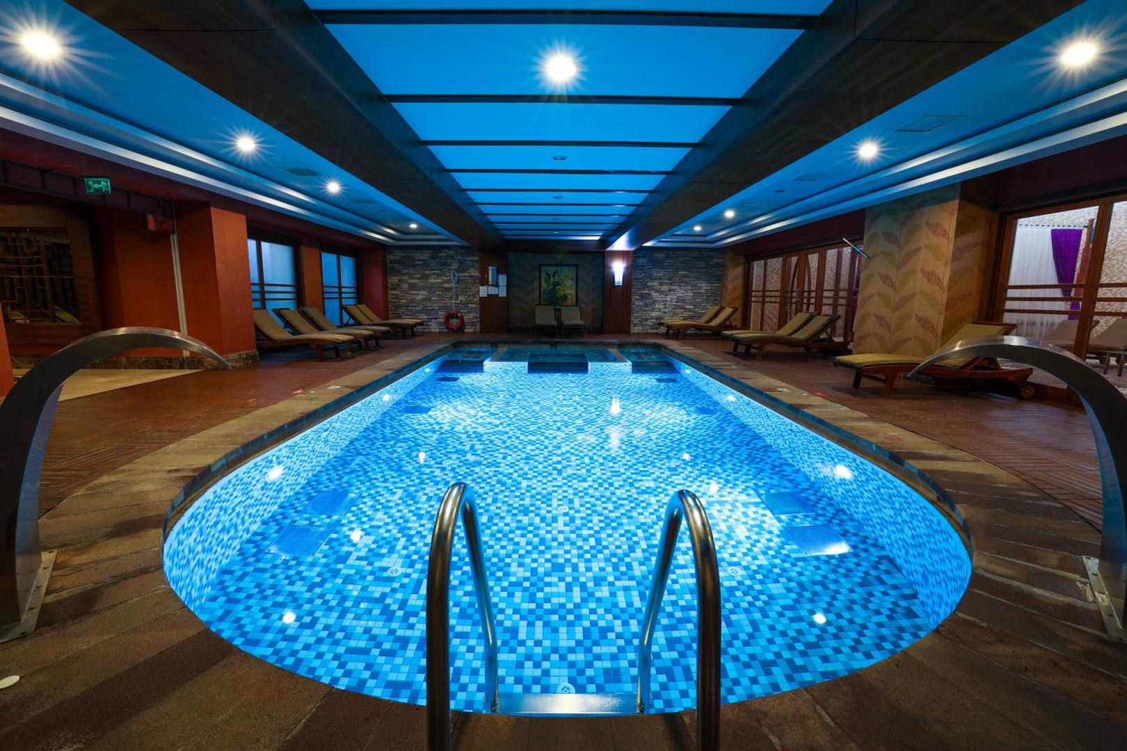 Crystal Palace Luxury Resort & Spa spa centra baseins ar masāžas strūklām un modernu apgaismojumu relaksācijas zonā