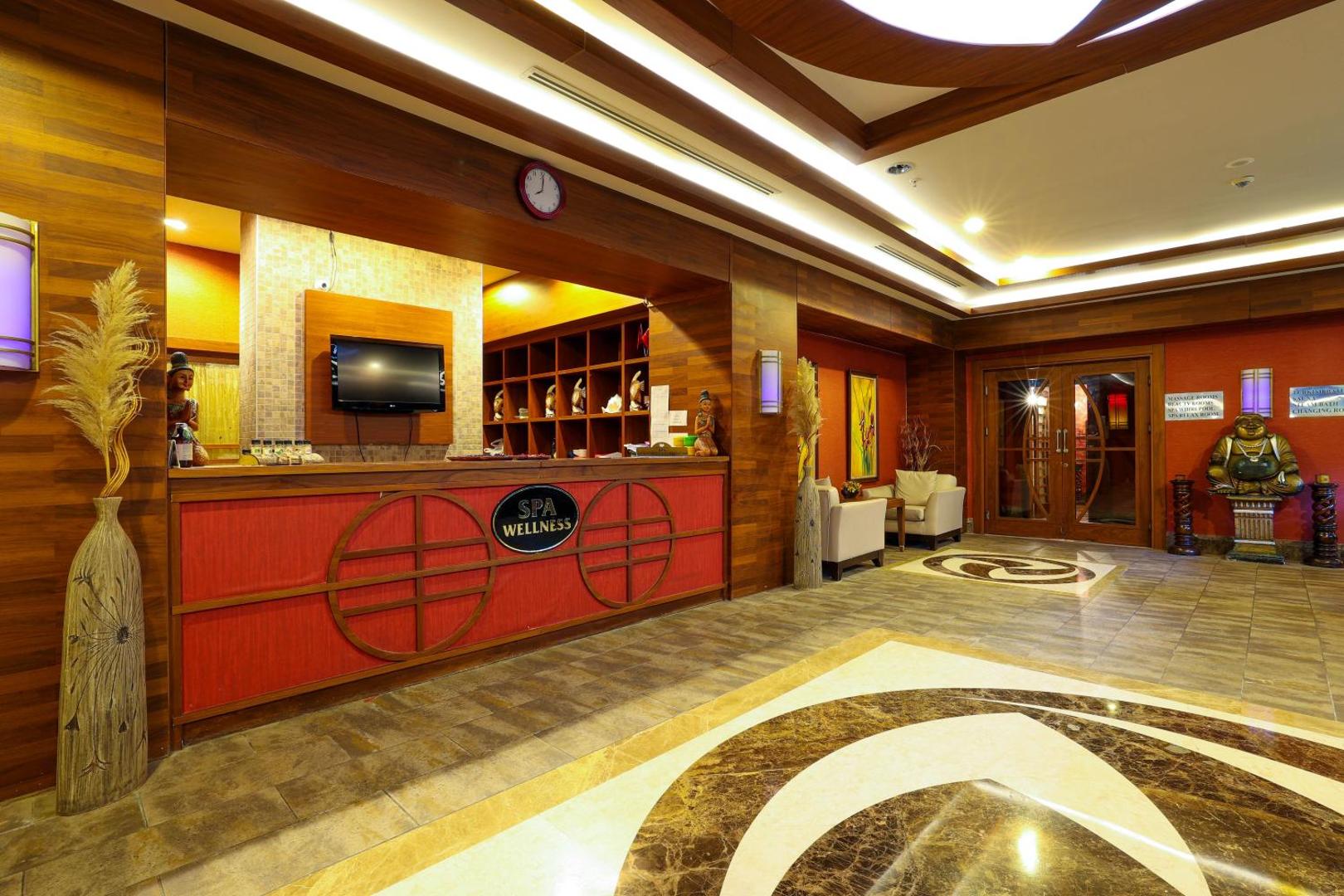 Crystal Palace Luxury Resort & Spa spa un labsajūtas centra recepcija ar koka apdari un austrumnieciskiem dekoriem