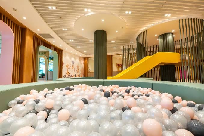 Calista Luxury Resort bērnu kluba iekštelpu rotaļu laukums ar lielu bumbu baseinu un dzeltenu slidkalniņu modernā dizainā