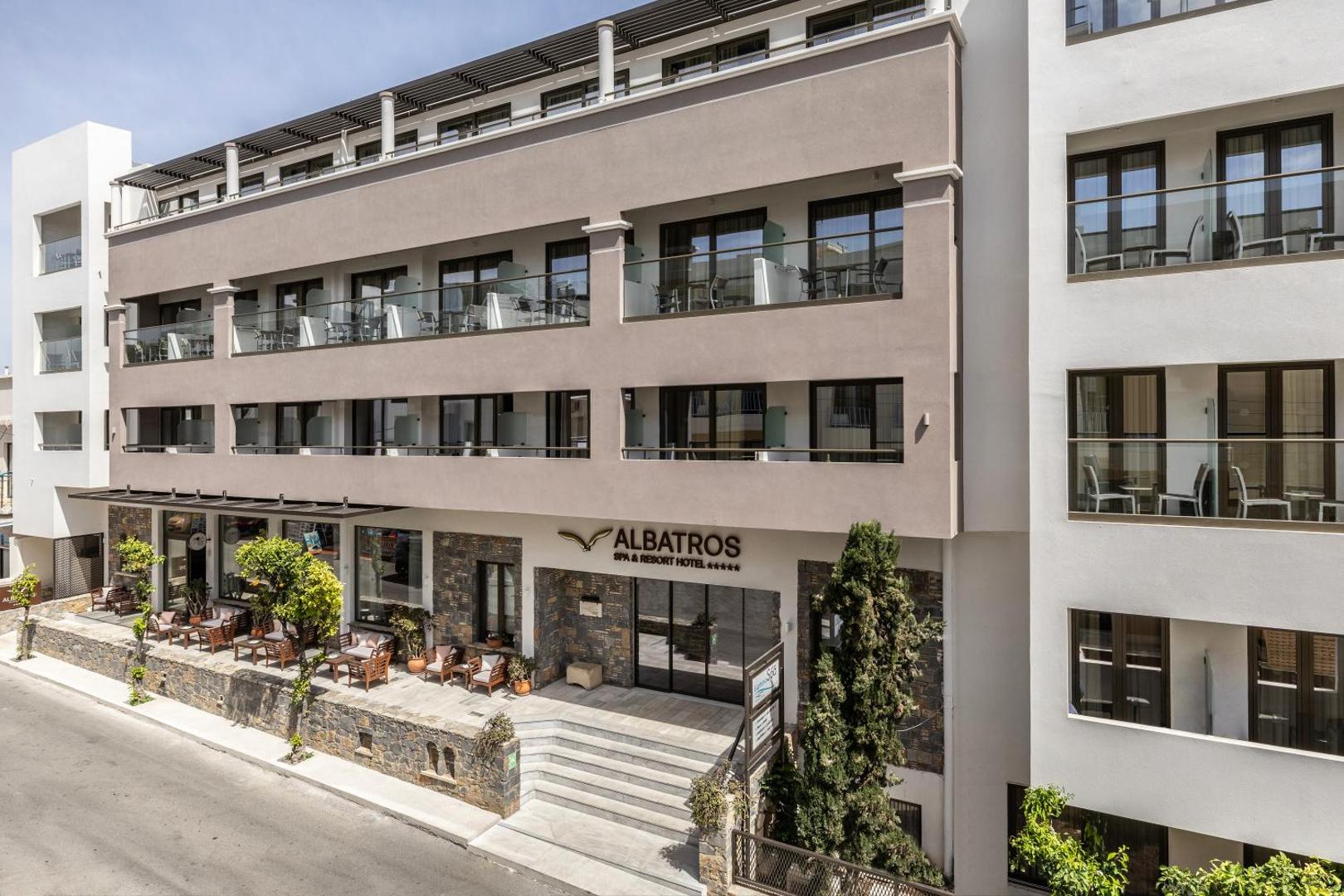 Albatros Spa & Resort 5* viesnīcas galvenā ieeja un fasāde Hersonisā ar āra terasi un atpūtas krēsliem.