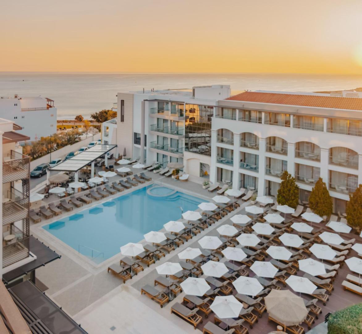 Albatros Spa & Resort skats no augšas uz baseina zonu ar saulessargiem un jūru fonā saulrieta laikā Hersonisā