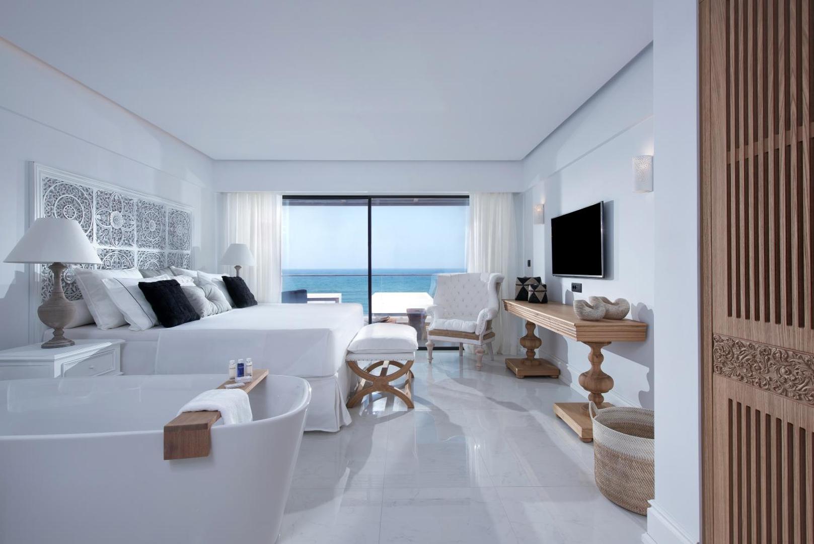 Abaton Island Resort & Spa luksusa numurs ar skatu uz jūru, brīvstāvošu vannu un elegantu baltu interjeru Krētā