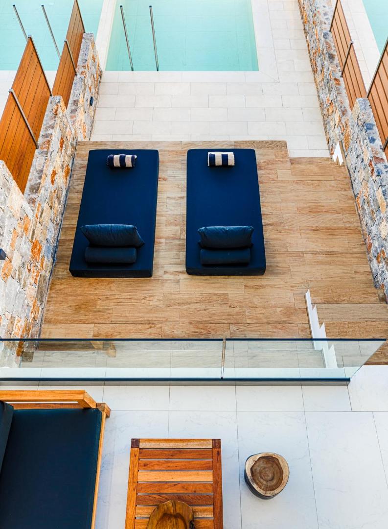 Skats no augšas uz Abaton Island Resort & Spa sauļošanās zonu ar mīkstiem zviļņiem un baseina malu