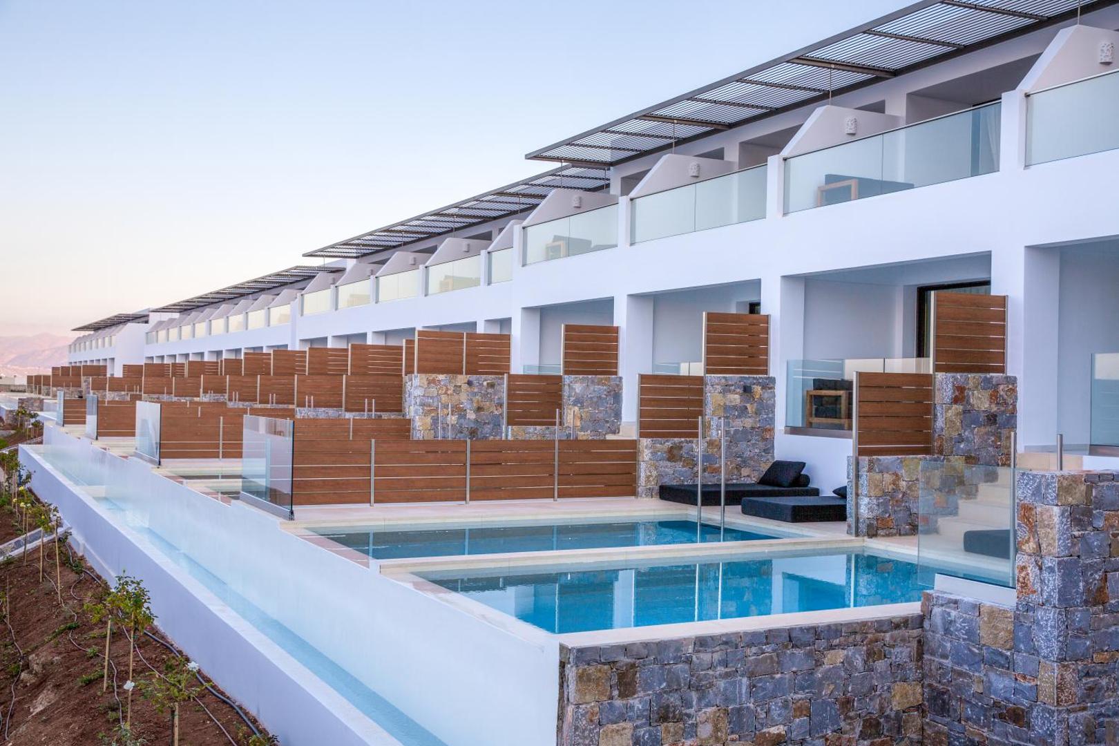 Abaton Island Resort & Spa rindu numuri ar privātiem baseiniem un stikla norobežojumiem Krētas piekrastē