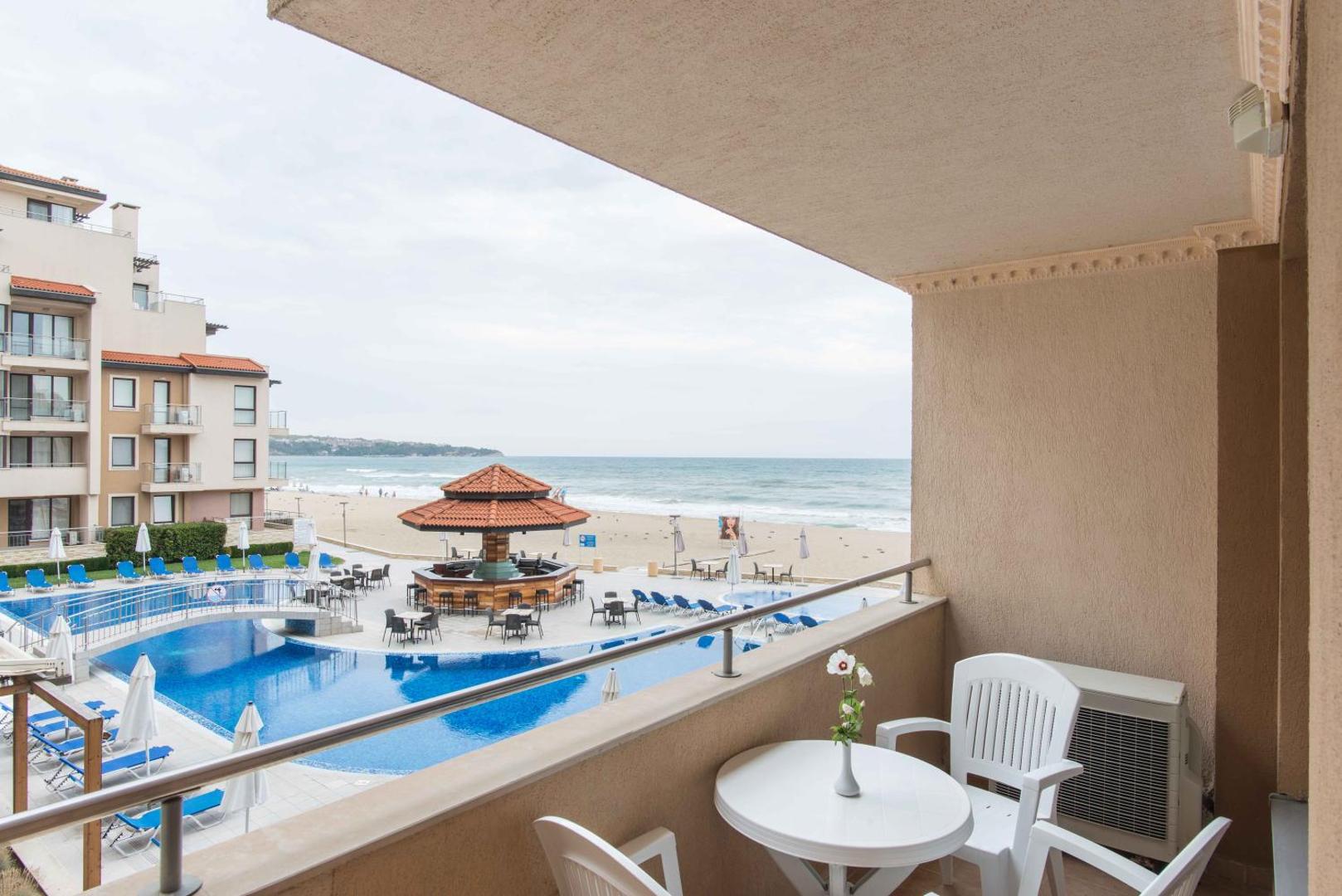 Skats no Obzor Beach Resort balkona uz āra baseinu, pludmales bāru un smilšu pludmali pie Melnās jūras