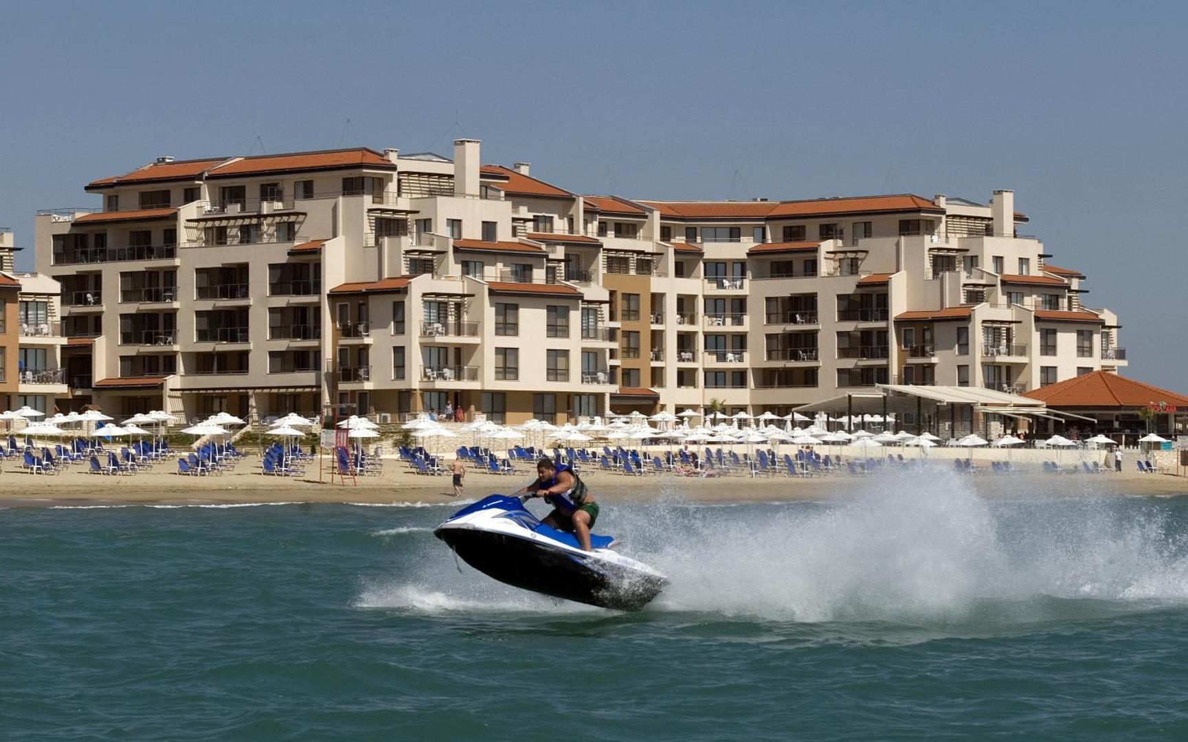 Obzor Beach Resort viesnīcas ēka piekrastē ar privāto pludmali, saulessargiem un ūdens motociklu jūrā