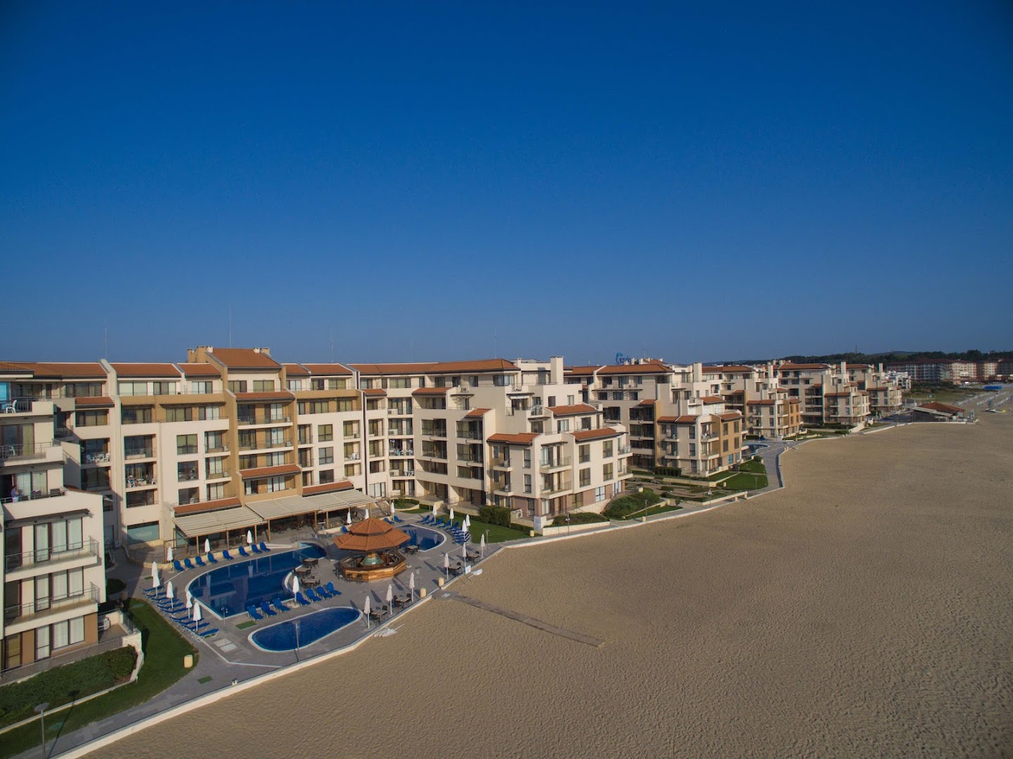 Obzor Beach Resort viesnīcas ēkas un āra baseini tiešā smilšu pludmales tuvumā Obzorā, Bulgārijā — skats no augšas uz kūrorta teritoriju