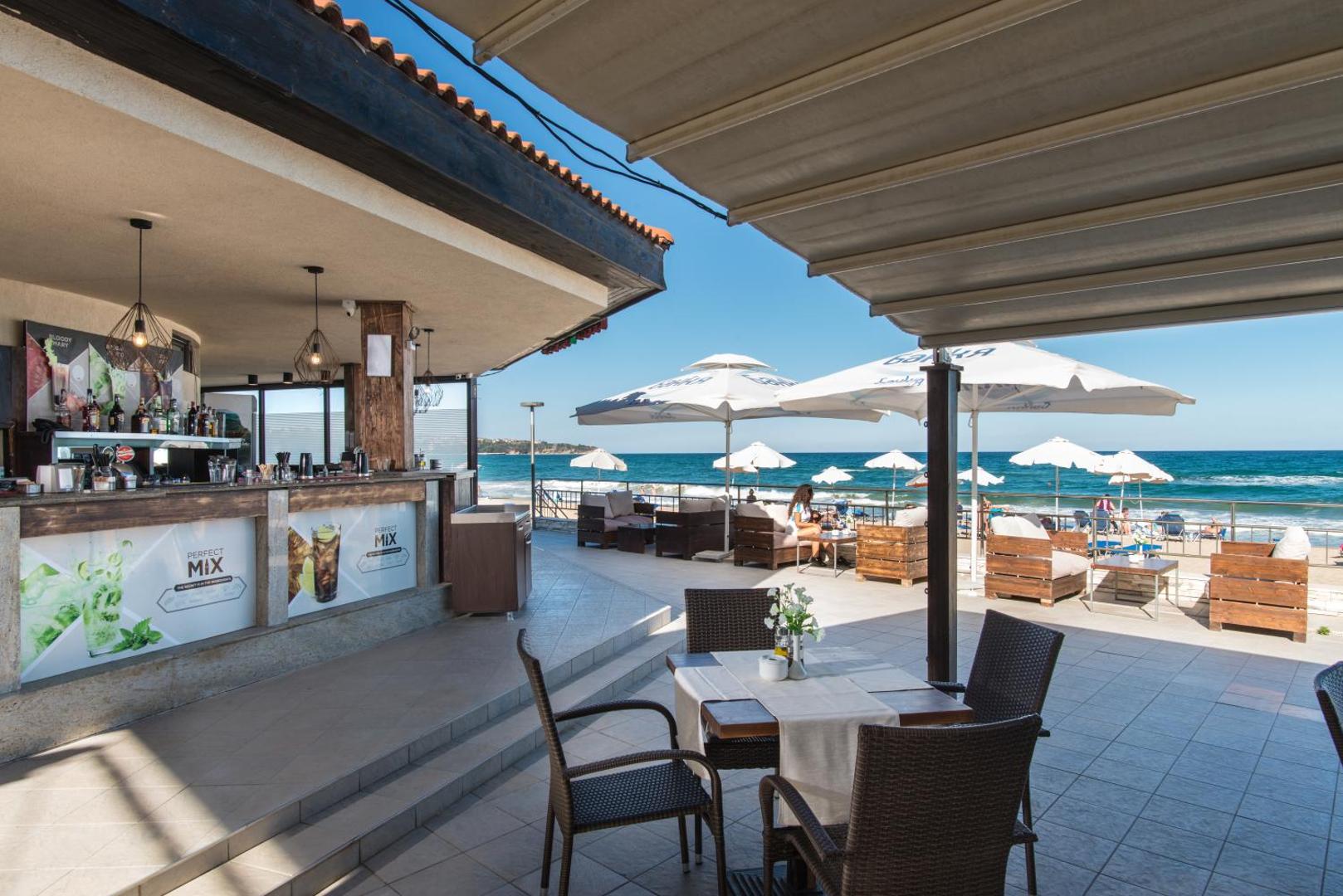 Obzor Beach Resort āra bārs un terase ar galdiņiem pie jūras krasta Obzorā — skats uz Melno jūru