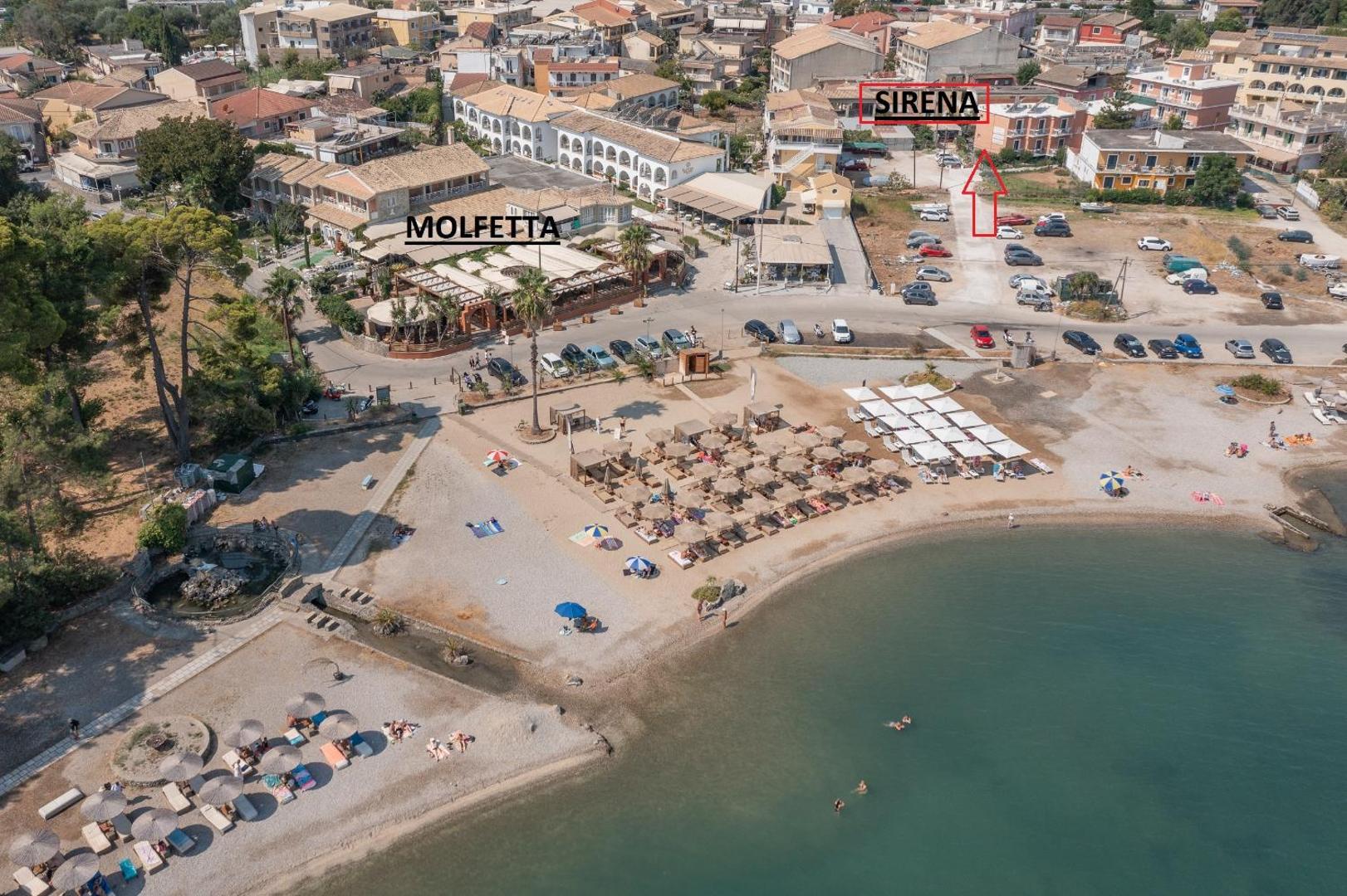 Aerofoto ar Molfetta Beach Hotel atrašanās vietu tieši pie Guvjas līča pludmales Korfu salā ar saulessargiem un jūru