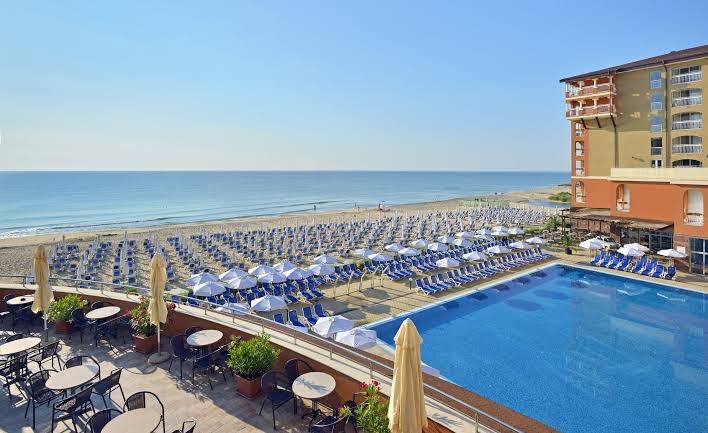 Skats no Sol Luna Bay Resort terases uz āra baseinu un plašo Melnās jūras pludmali ar saulessargiem