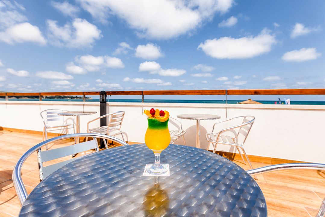 Eksotisks kokteilis uz Sol Luna Bay Resort terases galda ar skatu uz zilo Melno jūru un skaidrām debesīm.