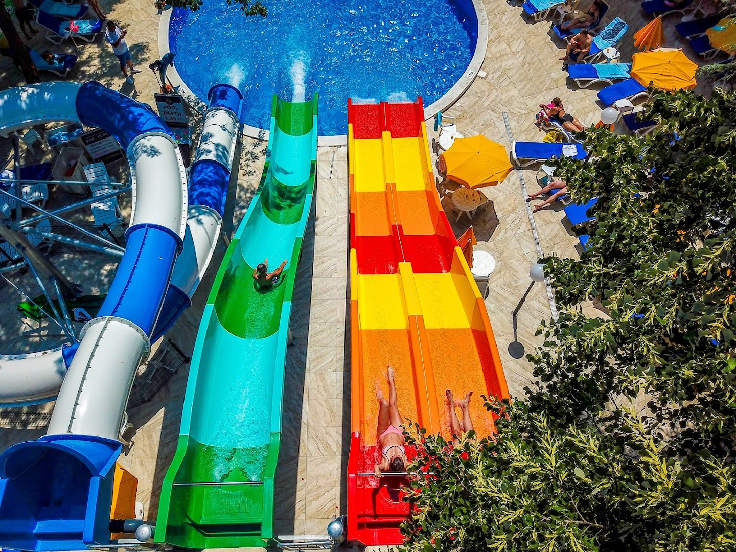 Skats no augšas uz Prestige Deluxe Hotel Aquapark Club krāsainajiem ūdens slidkalniņiem un baseinu