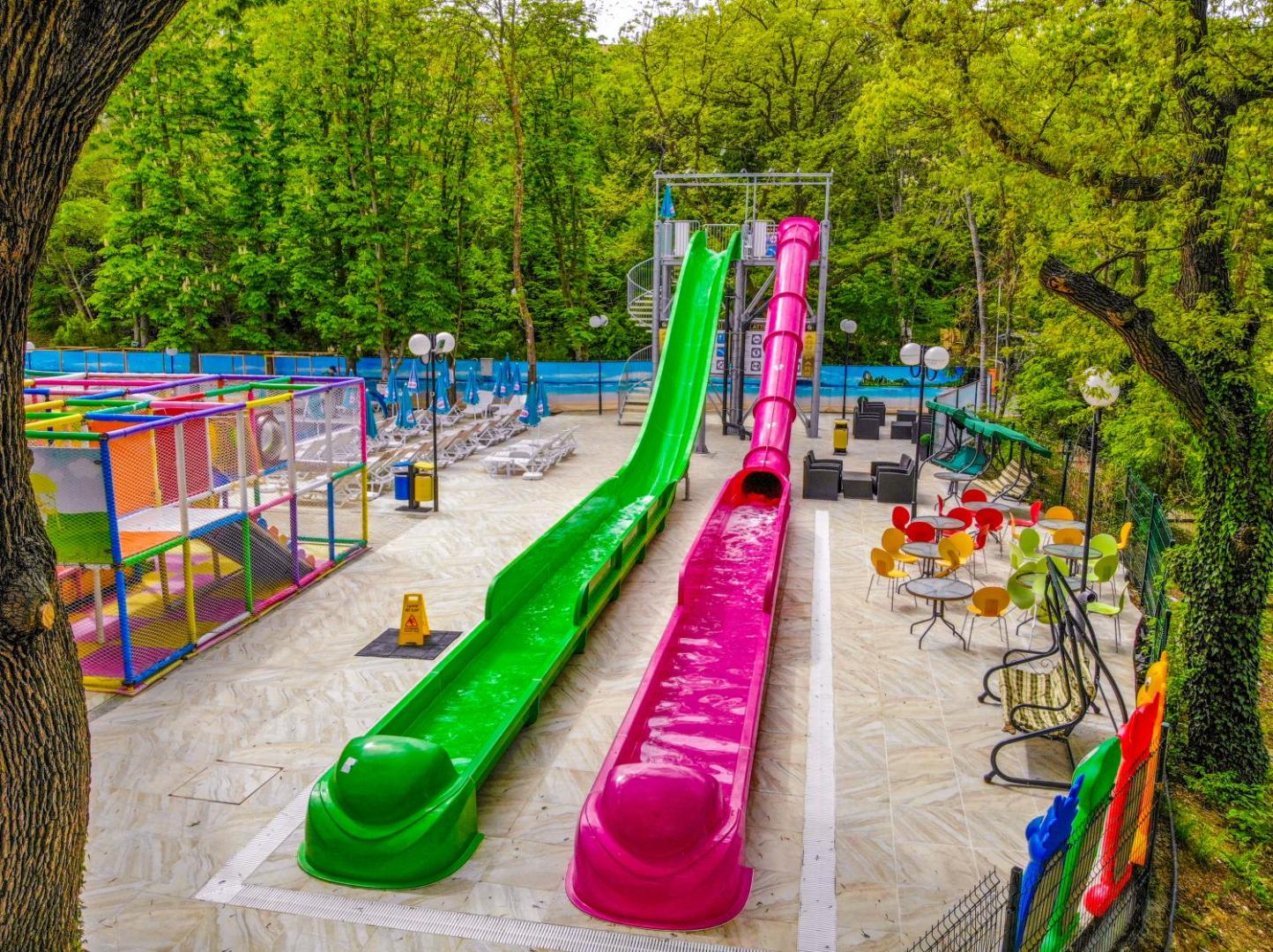 Prestige Deluxe Hotel Aquapark Club akvaparks ar diviem gariem ūdens slidkalniņiem, bērnu rotaļu laukumu un atpūtas zonu meža ieskāvumā.