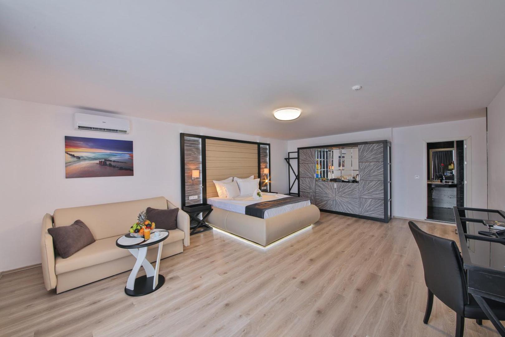 Plašs Prestige Deluxe Hotel Aquapark Club numurs ar lamināta grīdu, atpūtas zonu, gultu ar LED apgaismojumu un modernu interjeru