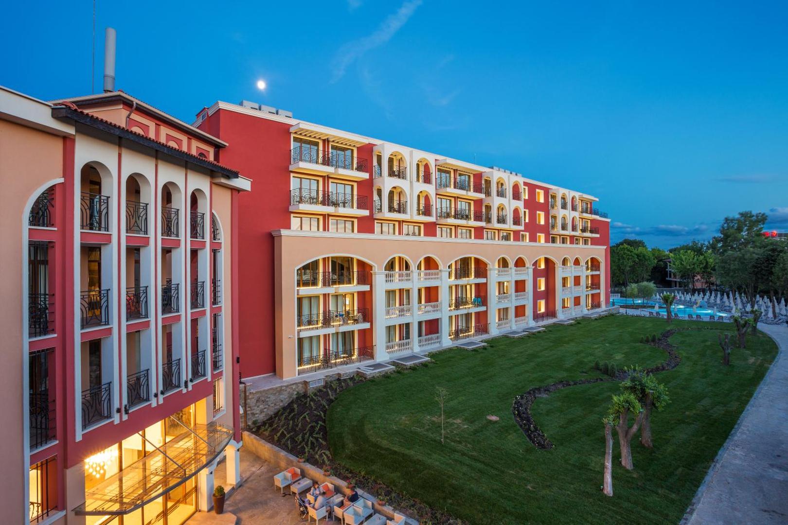 Festa Via Pontica Resort fasāde vakara apgaismojumā ar koptu zālāju un dārza zonu Pomorijā