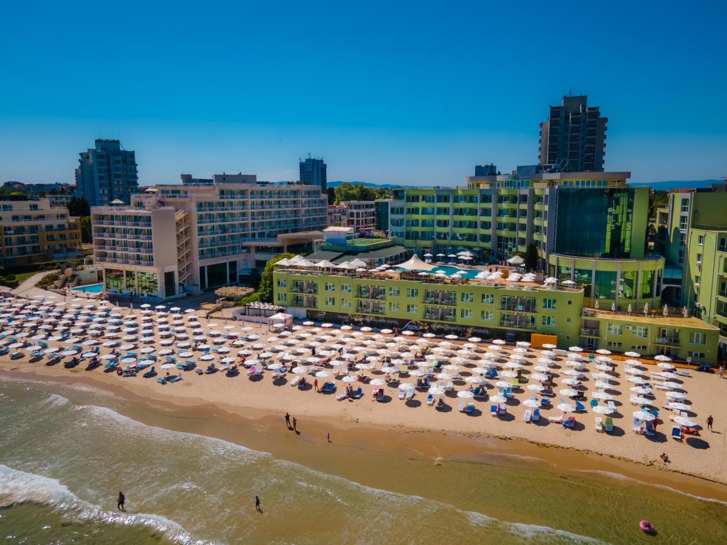 MPM Hotel Arsena viesnīcas ēka un privātā pludmale ar saulessargiem Saulainajā krastā, Bulgārijā — skats no putna lidojuma