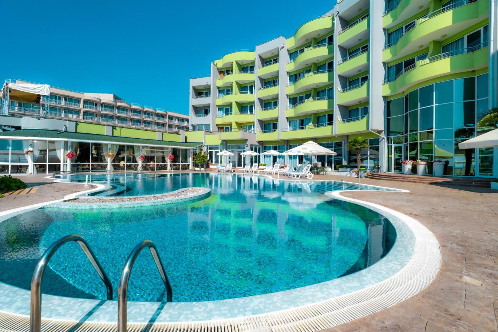 MPM Hotel Arsena modernā ēkas fasāde ar balkoniem un plašu āra baseinu saulainā dienā Nesebāras kūrortā